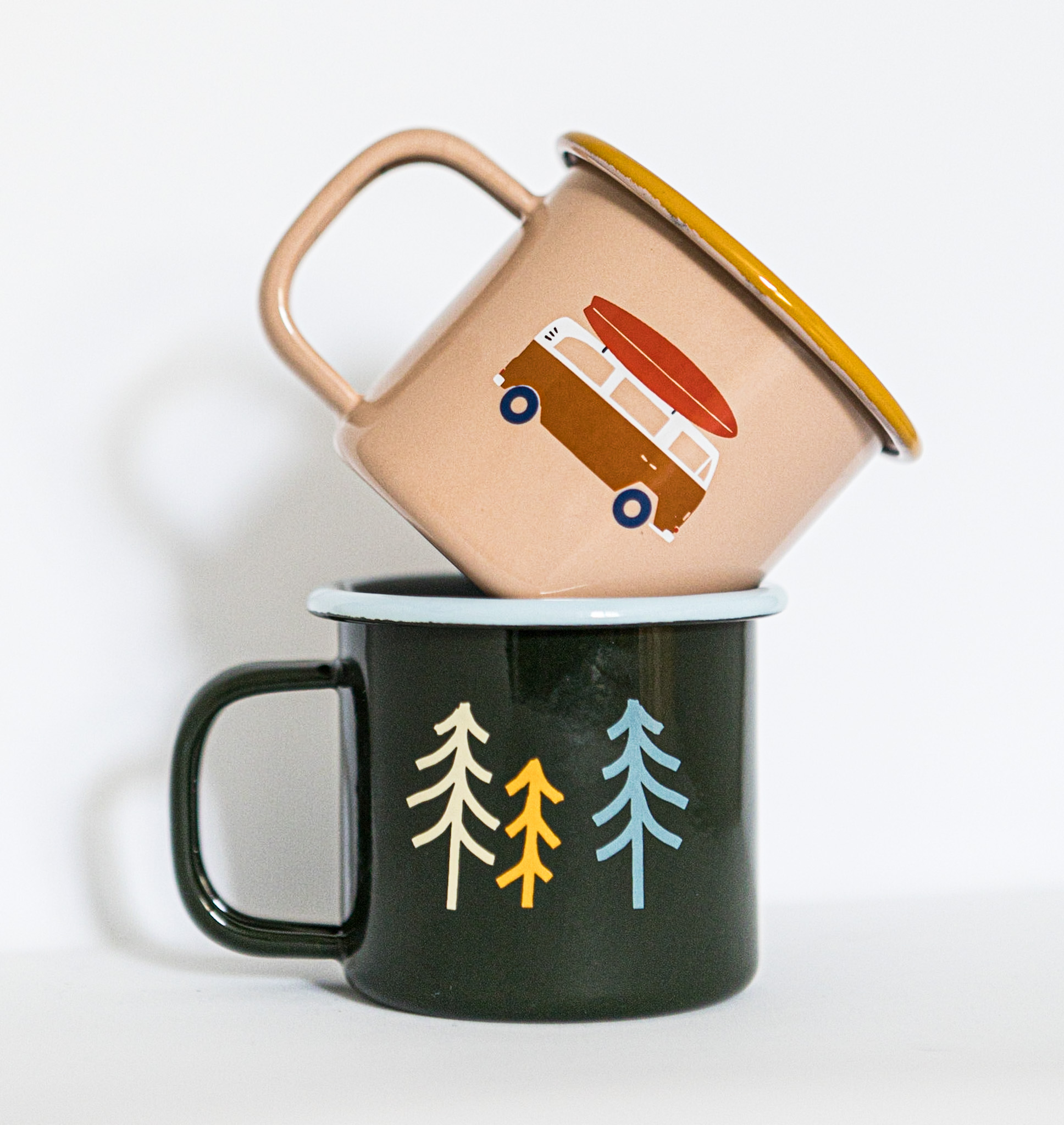 Zwei Emaille Tassen in beige mit einem Van und Surfboard und die andere Tasse in schwarz mit farbigen Tannen