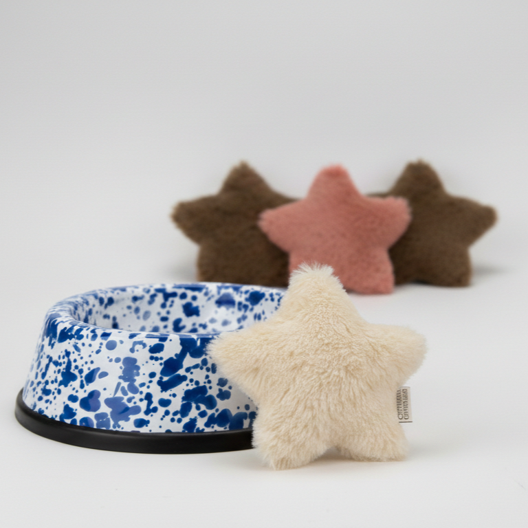 Weihnachtsstern Kuscheltier Kissen in braun, rosa und weiß, sowie eine blau gemusterter Emaille Napf