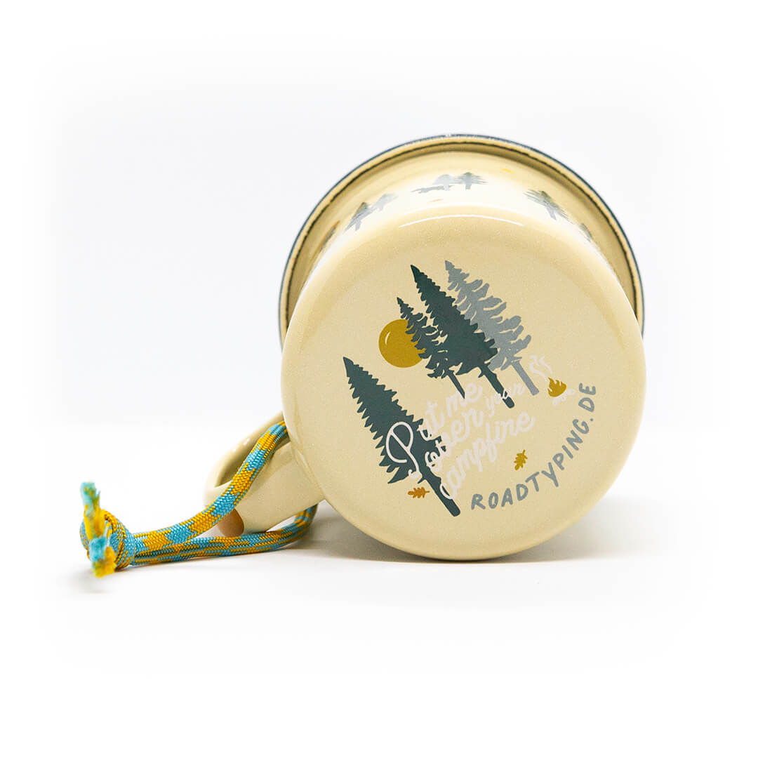 gelbe Emaille Tasse mit schwarzem Rand und einem Aufdruck von Bäumen und den Worten 'Put me over your campfire' an der Unterseite