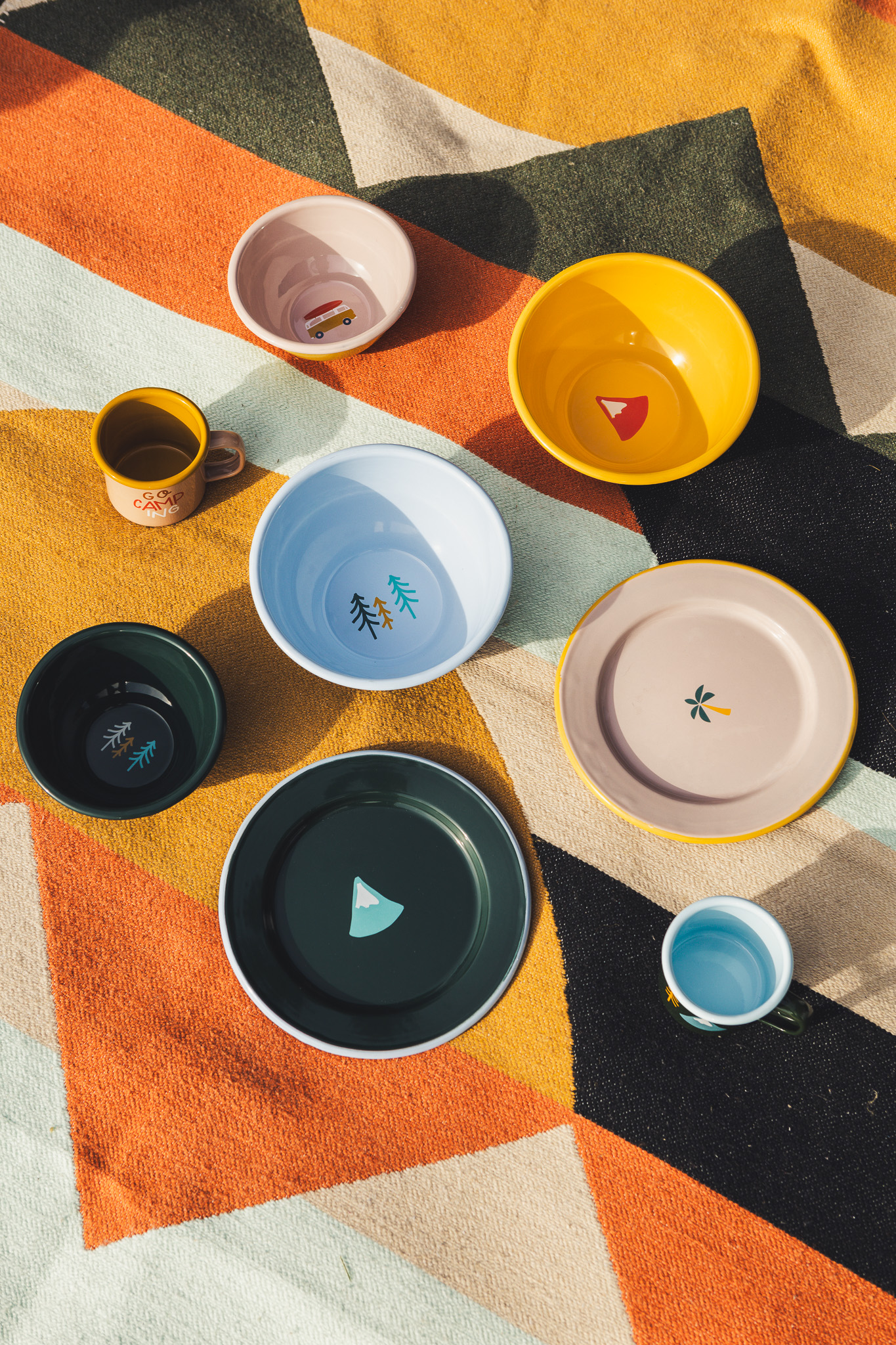 Bunte Emaille Schalen und Teller auf einer bunten Picknickdecke